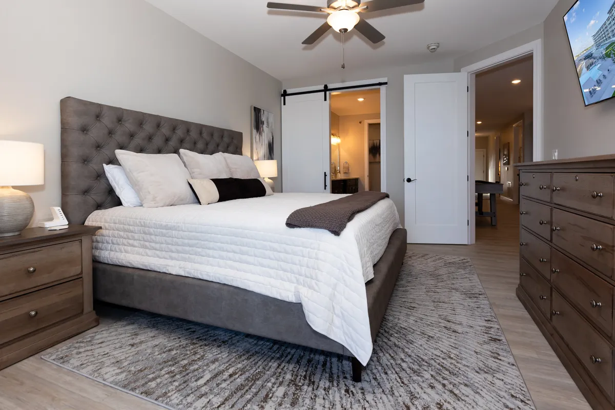 Another inviting bedroom with a cozy bed, matching nightstands, dresser, and a sliding door. The space is calm and uncluttered, suggesting plenty of personal space to relax and unwind.