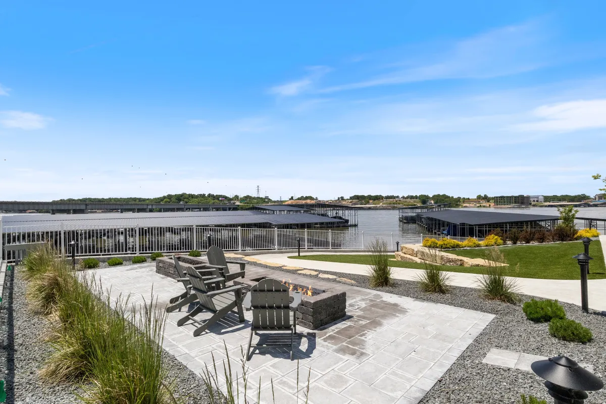 A tranquil lakeside setting featuring a fire pit surrounded by Adirondack chairs, all positioned to enjoy stunning waterfront views. The ambiance is peaceful, ideal for unwinding after an active day on the lake.